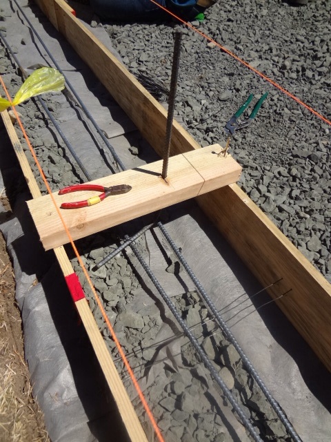Every 3-4ft, wire is run perpendicular through the forms to hold up the horizontal rebar. Every ? Inches, 2x4's with vertical rebar (?) are attached across the forms. The vertical rebar will protrude into the space of the ICF blocks (Faswall blocks) that will be placed on top of the bond beam.